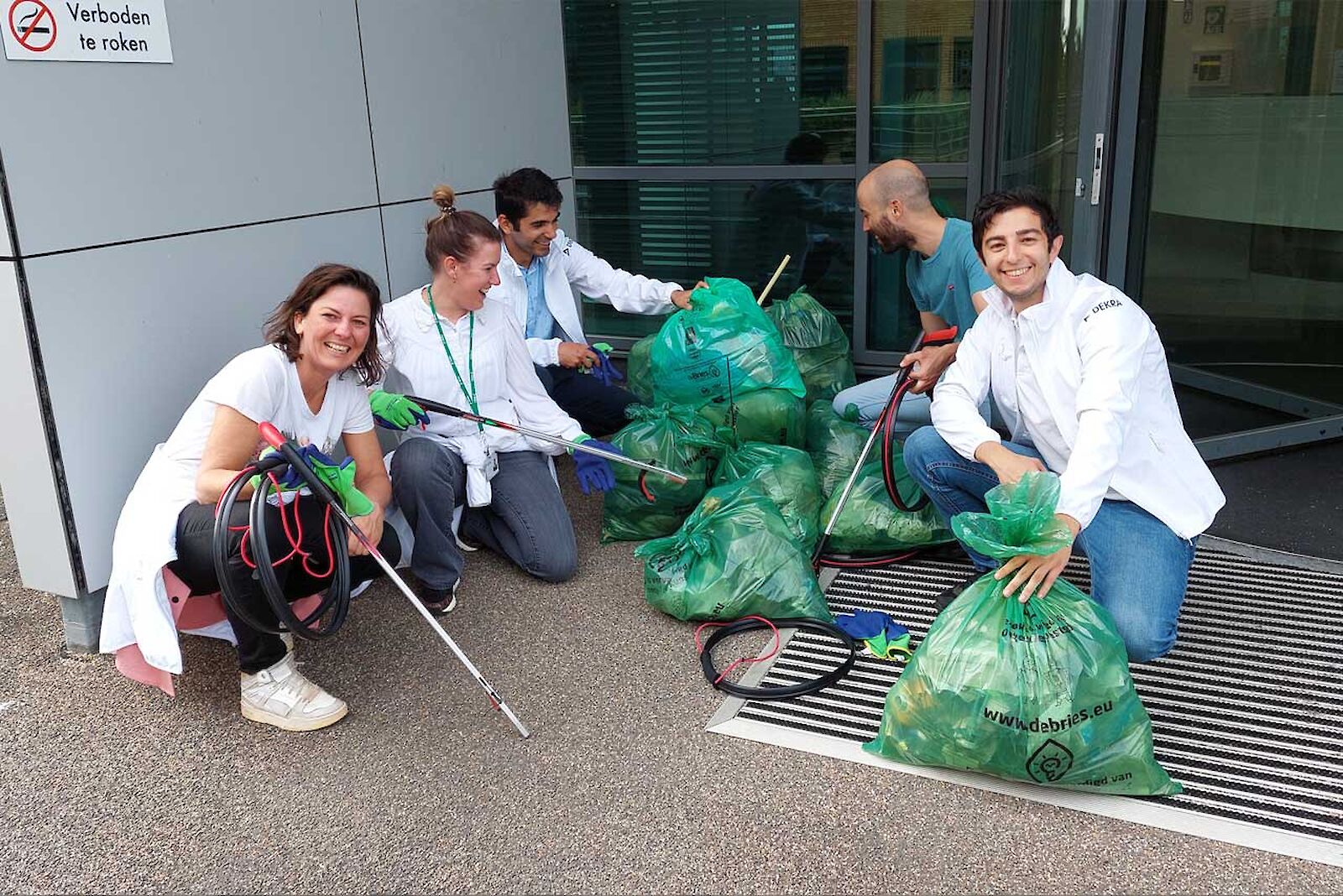 DEKRA employees present the full bin liners they have collected.